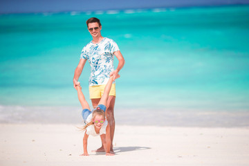 Happy father and his adorable little daughter at tropical beach having fun