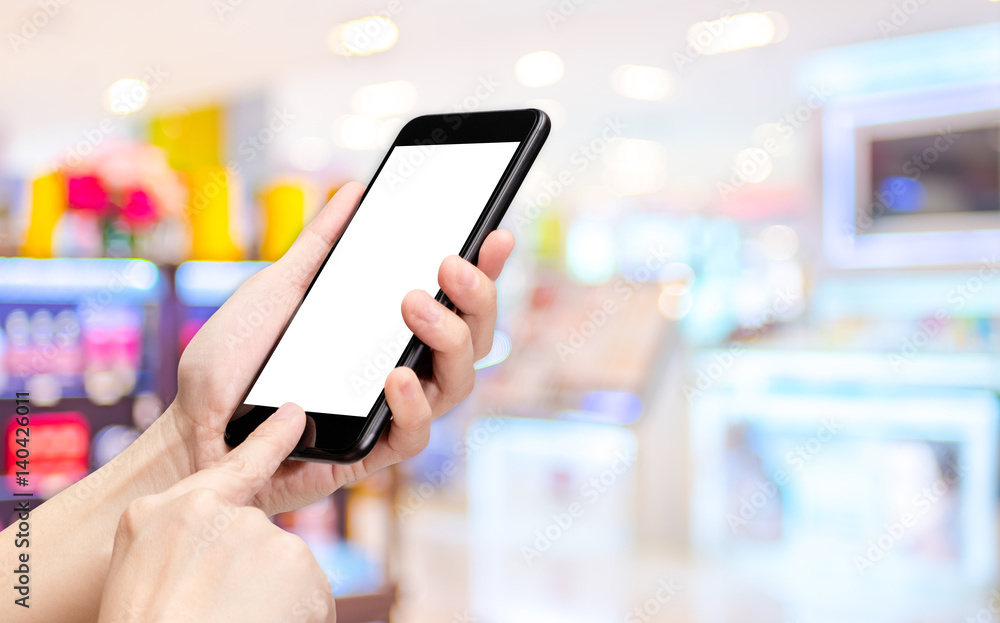 Fototapete Hand click mobile phone with blur department store background bokeh light,White screen mock up template for adding your design or your text