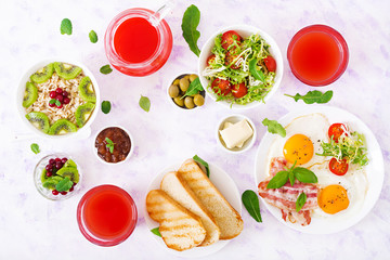 English breakfast - fried egg, tomatoes and bacon. Breakfast for two. Oatmeal. Flat lay. Top view