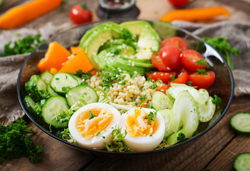 Diet menu. Healthy lifestyle. Bulgur porridge, egg and fresh vegetables - tomatoes, cucumber, celery and avocado on plate.