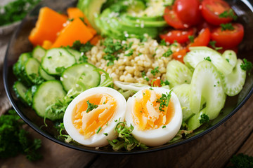 Diet menu. Healthy lifestyle. Bulgur porridge, egg and fresh vegetables - tomatoes, cucumber, celery and avocado on plate.