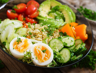 Diet menu. Healthy lifestyle. Bulgur porridge, egg and fresh vegetables - tomatoes, cucumber, celery and avocado on plate.
