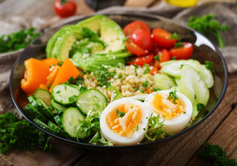 Diet menu. Healthy lifestyle. Bulgur porridge, egg and fresh vegetables - tomatoes, cucumber, celery and avocado on plate.