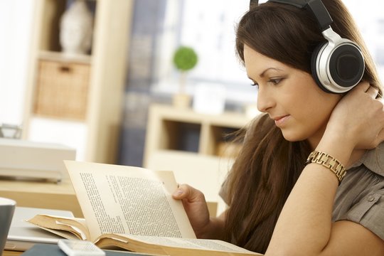 Side view of reading woman with headphones