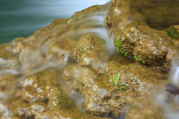waterfall with rock and clear green with blue water for relax feel with plant or lichen in the jungle at Huay Mae Khamin waterfall for fresh nature landscape