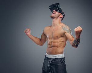 A shirtless, tattooed fighter with virtual reality glasses on his head.