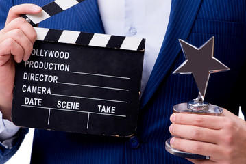 Handsome man with movie clapper isolated on white
