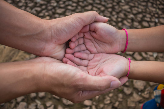 Father and children hold hands to help each other across the drought.
