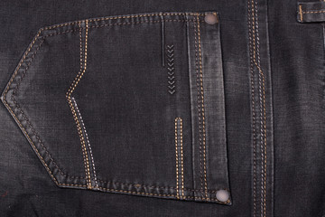 back pocket of dark jeans close up