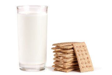 glass of milk with stack of grain crispbreads isolated on white background