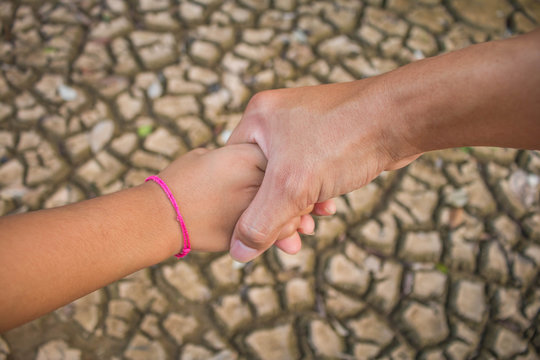 Father and children hold hands to help each other across the drought ,Drought concept.
