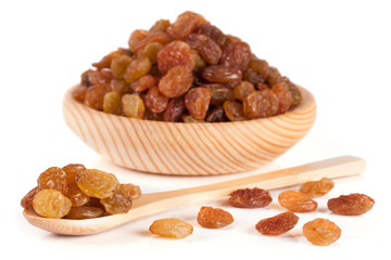 raisins in a wooden bowl with spoon isolated on white background