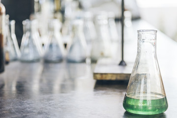 detail shot of beakers and equipment on table in factory laboratory.