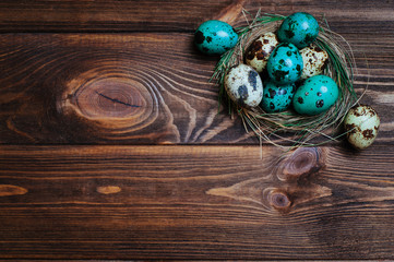 Fototapeta na wymiar Painted quail eggs in natural nest over rustic wooden background