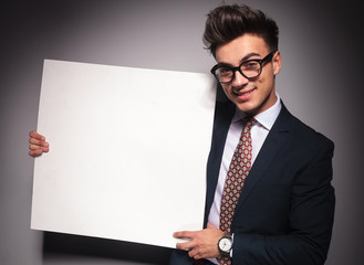 young happy businessman presenting a blank board