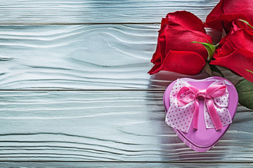 Composition of metal heart-shaped present boxes red roses on woo