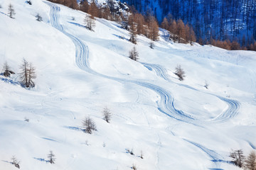 Fototapeta na wymiar Skis or snowboarding traces on snow-covered slope