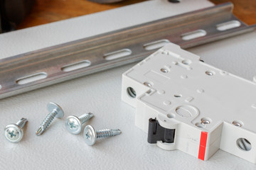 DIN rail, circuit breaker and the screws on the mounting plate
