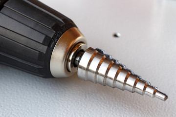 Step drill in the chuck of the screwdriver