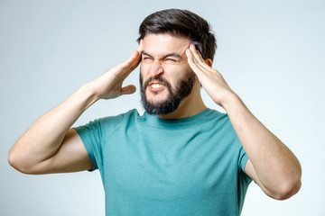 Naklejka premium Depressed handsome bearded man touching having a headache