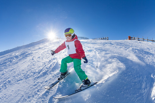 Active kid boy skiing in mountains at sunny day