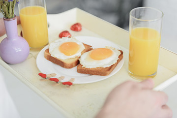 Cheerful man carrying romantic breakfast