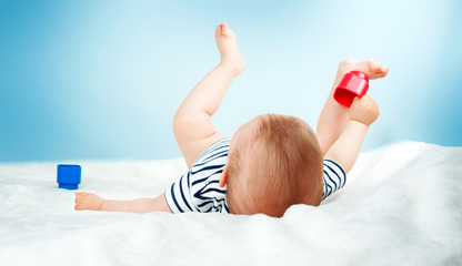 Nine month old baby lying in the bed on white blanket