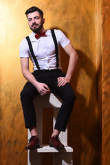 bearded man sitting on chair with serious face