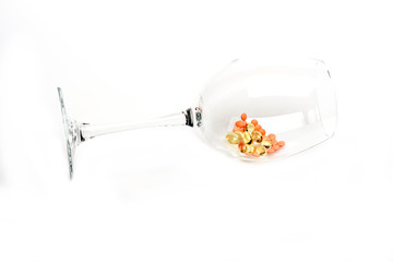 Red pills and capsules of cod-liver oil in glass