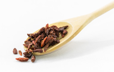 Wooden spoon with dried goji berry. Goji berries isolated on white.