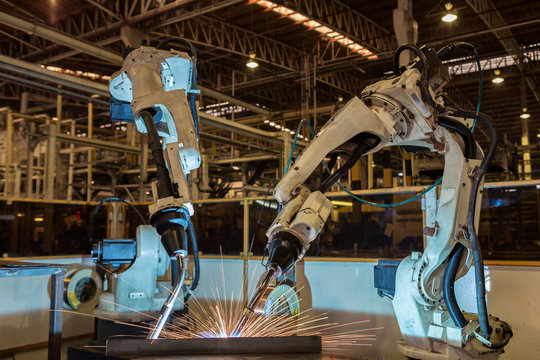 Team robots are welding assembly part  in car factory