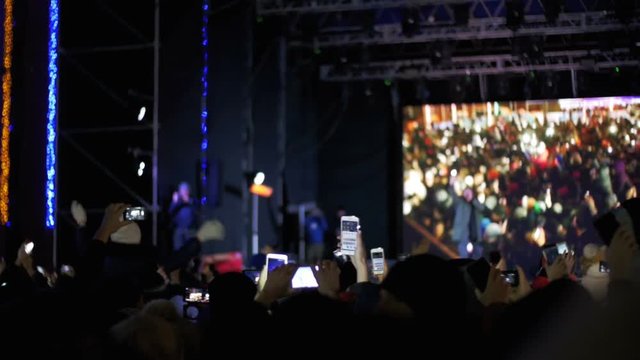 Crowd Making Party at a Rock Concert. Hands Hold Cameras with Digital Displays