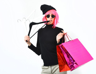 fashionable sexy girl in pink wig holding package with hangers
