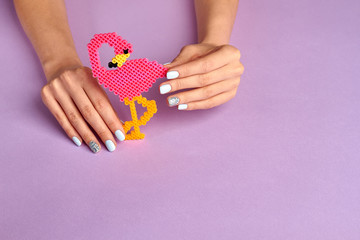 Toy pink flamingo in beautiful female hands.