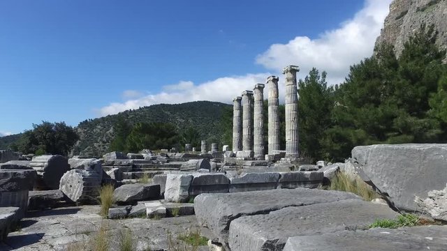 General temple view with columns around of Priene Ancient City in Aydın, Turkey, on bright blue sky background.