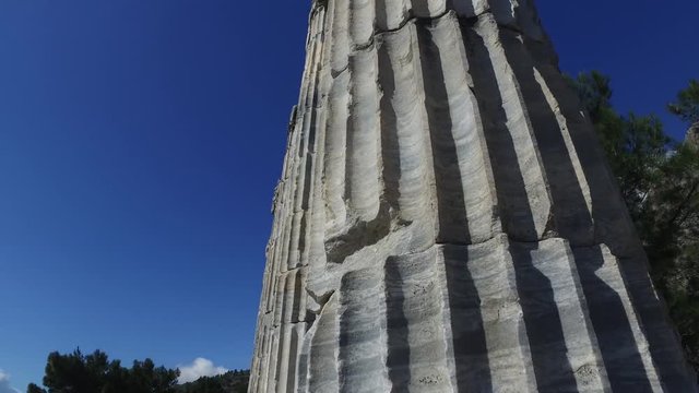 General temple view with columns around of Priene Ancient City in Aydın, Turkey, on bright blue sky background.