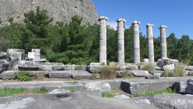 General temple view with columns around of Priene Ancient City in Aydın, Turkey, on bright blue sky background.