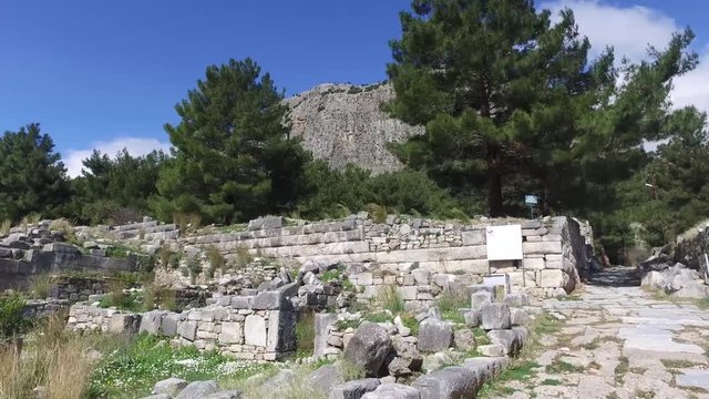 General temple view with columns around of Priene Ancient City in Aydın, Turkey, on bright blue sky background.