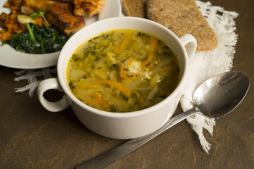 Cabbage soup, roasted Turkey with vegetables on wooden table. Shchi, traditional Russian cuisine.