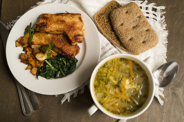 Cabbage soup, roasted Turkey with vegetables on wooden table. Shchi, traditional Russian cuisine.