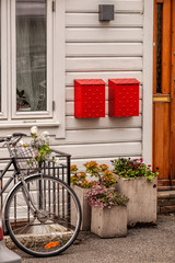 Wooden house with bike against red postboxes in Bergen. UNESCO World Heritage Site, Norway