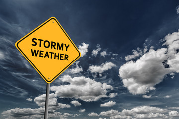 Dark blue cloudy sky and yellow road sign