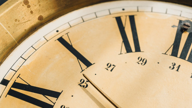 Close-up of Roman numerals on the dial of the wall clock.