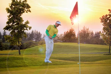 Photo sur Aluminium Golf Man playing golf against colorful sunset