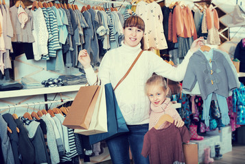 Fototapeta na wymiar Smiling mother and girl enjoying their purchases