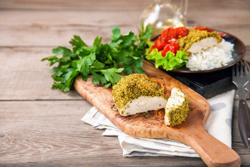 Chicken fillet in a green breading with a garnish. Selective focus. Copy space.