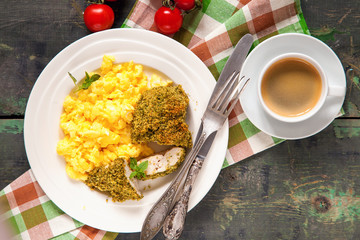 Breakfast - an omelet, chicken fillet in a green breading and coffee on a table. Selective focus. Top view. Copy space.