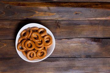 Russian bagels, bread in a white plate on wooden background