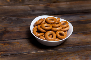 Russian bagels, bread in a white plate on wooden background