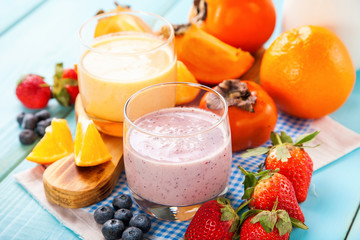 Orange persimmon blueberry smoothie with granola  and fruits. Selective focus. Copy space